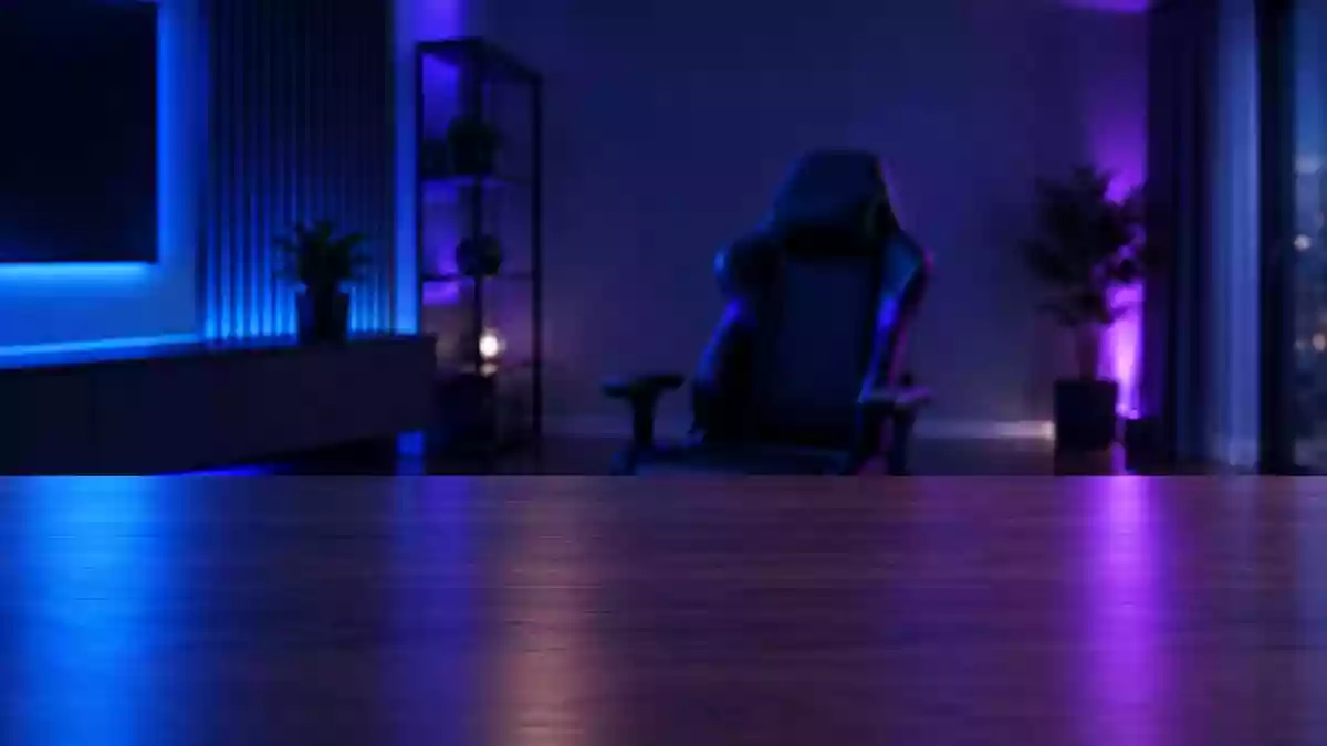 Ein minimalistisch eingerichteter, abgedunkelter Gaming-Raum mit stimmungsvoller Beleuchtung und einem leeren Schreibtisch. Illustration mit AI erstellt.