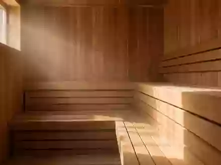Leeres, minimalistisches Interieur einer finnischen Holzsauna mit hellen Holzbänken in warmem Licht. - Foto: über boerse-global.de