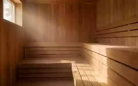 Leeres, minimalistisches Interieur einer finnischen Holzsauna mit hellen Holzbänken in warmem Licht. - Foto: über boerse-global.de