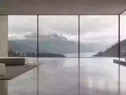 Ein minimalistischer, heller Innenraum mit weichem Tageslicht und Blick auf eine ruhige Berglandschaft. - Foto: über boerse-global.de