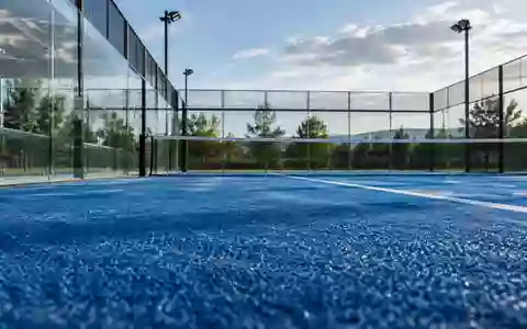 Ein leerer Padel-Platz mit blauem Kunstrasen und Glaswänden bei natürlichem Tageslicht. - Foto: über boerse-global.de