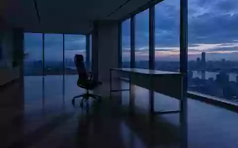 Ein leerer, ruhig wirkender Büroraum in der Dämmerung mit einem einzelnen Stuhl vor einem aufgeräumten Schreibtisch. - Foto: über boerse-global.de
