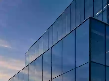 Moderne Glasfassade eines Bürogebäudes in der Dämmerung mit geometrischen Reflexionen. - Foto: über boerse-global.de