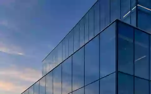 Moderne Glasfassade eines Bürogebäudes in der Dämmerung mit geometrischen Reflexionen. - Foto: über boerse-global.de