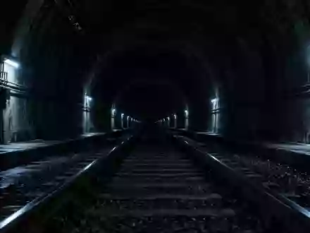 Leerer Eisenbahntunnel mit Schienen und Notbeleuchtung - Foto: über boerse-global.de