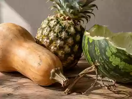 Nahaufnahme von verschiedenen Obst- und Gemüseresten wie Kürbisschalen und Ananasschalen auf einer rustikalen Holzoberfläche. - Foto: über boerse-global.de