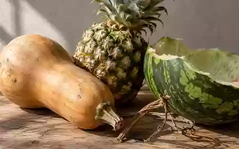 Nahaufnahme von verschiedenen Obst- und Gemüseresten wie Kürbisschalen und Ananasschalen auf einer rustikalen Holzoberfläche. - Foto: über boerse-global.de