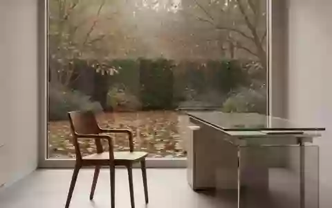 Ein minimalistischer, heller medizinischer Beratungsraum mit Blick auf einen herbstlichen Garten. - Foto: über boerse-global.de