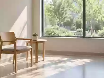 Ein minimalistisch eingerichteter, lichtdurchfluteter Beratungsraum in einer medizinischen Einrichtung mit Blick in einen Garten. - Foto: über boerse-global.de