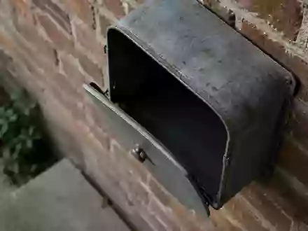 Ein Briefkasten aus Metall an einer Ziegelwand bei natürlichem Tageslicht. - Foto: über boerse-global.de