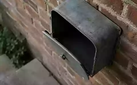 Ein Briefkasten aus Metall an einer Ziegelwand bei natürlichem Tageslicht. - Foto: über boerse-global.de