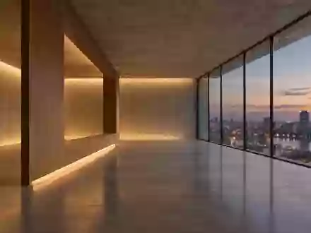 Ein minimalistischer, leerer Innenraum mit großen Glasfenstern und Blick auf eine verschwommene städtische Dämmerung. - Foto: über boerse-global.de