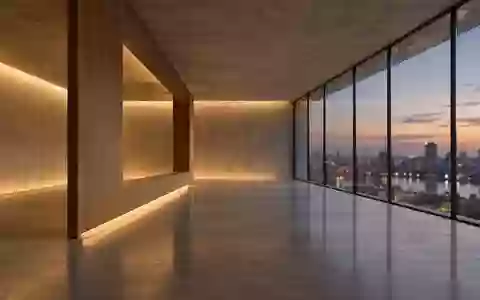 Ein minimalistischer, leerer Innenraum mit großen Glasfenstern und Blick auf eine verschwommene städtische Dämmerung. - Foto: über boerse-global.de