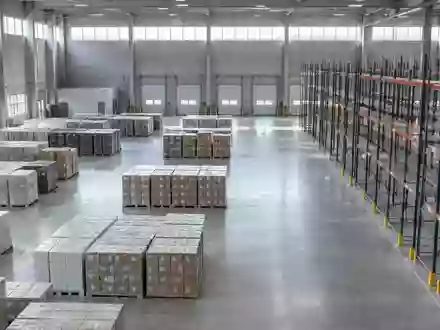 Ein weites, modernes Industrielager mit leeren Regalen und gestapelten Paletten in einer ruhigen, minimalistischen Umgebung. - Foto: über boerse-global.de