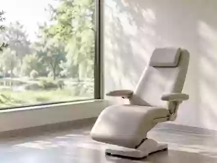 Ein ruhiger, minimalistischer Therapieraum mit einem leeren Sessel vor einem Fenster mit Blick ins Grüne. - Foto: über boerse-global.de