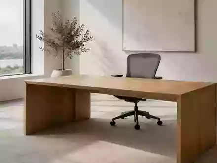 Ein minimalistisches, modernes Büro mit einem leeren Schreibtisch und einem Stuhl in natürlichem Licht. - Foto: über boerse-global.de