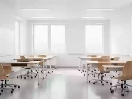 Ein heller, leerer Unterrichtsraum mit minimalistischem Design und Holztischen, der eine moderne Lernumgebung symbolisiert. - Foto: über boerse-global.de