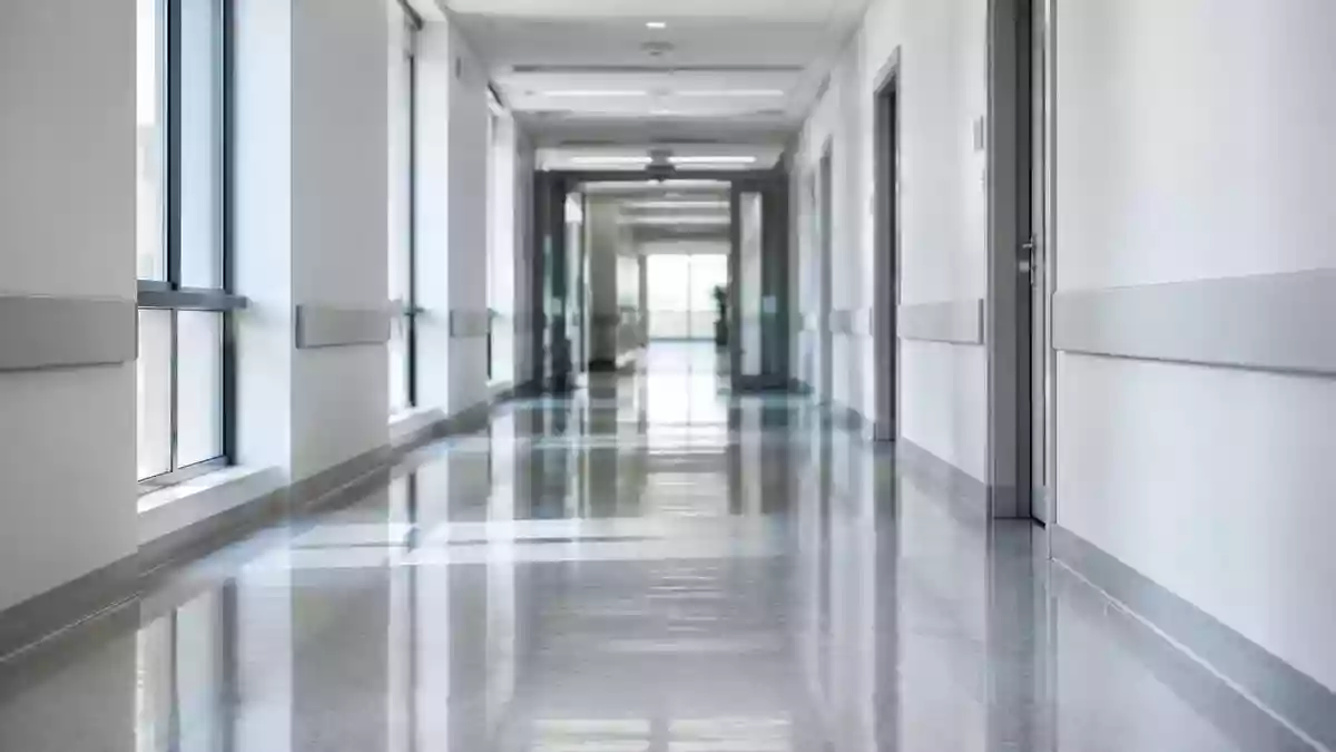 Ein leerer, modern gestalteter Krankenhausflur mit hellen Wänden und reflektierendem Bodenbelag. Illustration mit AI erstellt.