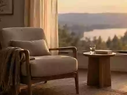 Ein ruhiges, minimalistisch eingerichtetes Wohnzimmer bei Sonnenuntergang mit einem bequemen Sessel und einem Buch. - Foto: über boerse-global.de