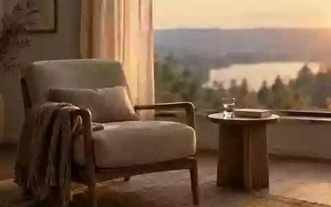 Ein ruhiges, minimalistisch eingerichtetes Wohnzimmer bei Sonnenuntergang mit einem bequemen Sessel und einem Buch. - Foto: über boerse-global.de
