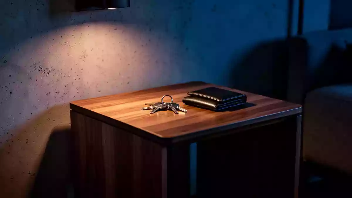 Ein minimalistischer Nachttisch in einer dunklen, modern eingerichteten Wohnung bei Nacht. Illustration mit AI erstellt.