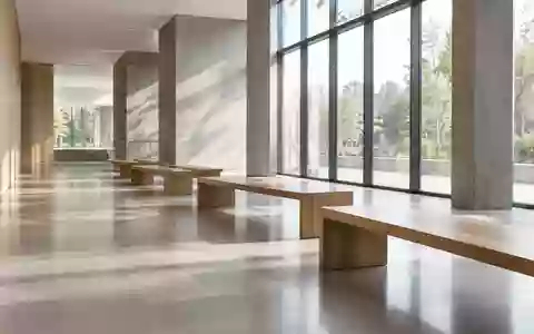 Ein minimalistischer, heller Innenraum eines modernen öffentlichen Gebäudes mit leeren Holzsitzbänken und natürlichem Lichteinfall. - Foto: über boerse-global.de
