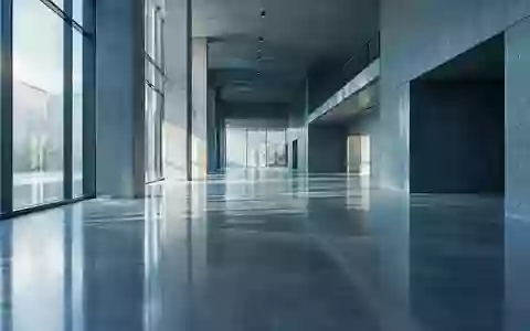 Ein minimalistischer, moderner Flur mit reflektierendem Betonboden und kühlem Lichteinfall ohne Personen. - Foto: über boerse-global.de