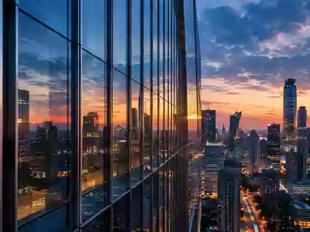 Moderne Glas- und Stahlfassade eines Hochhauses in einer chinesischen Metropole bei Dämmerung. - Foto: über boerse-global.de