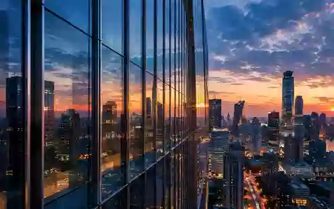 Moderne Glas- und Stahlfassade eines Hochhauses in einer chinesischen Metropole bei Dämmerung. - Foto: über boerse-global.de