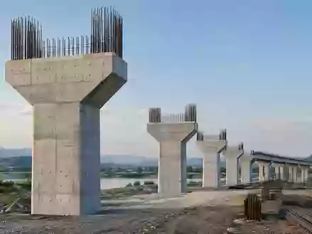Eine moderne Betonbrückenbaustelle in einer ruhigen Landschaft bei Tageslicht. - Foto: über boerse-global.de