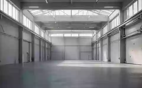 Eine moderne, minimalistische Industriehalle mit weiten Betonböden und einfallendem Tageslicht als Symbol für technologischen Wandel. - Foto: über boerse-global.de