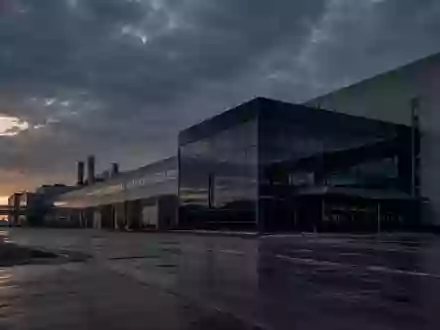 Ein großes, stilles Industriegelände eines Automobilwerks in der Dämmerung mit imposanter Architektur unter bewölktem Himmel. - Foto: über boerse-global.de