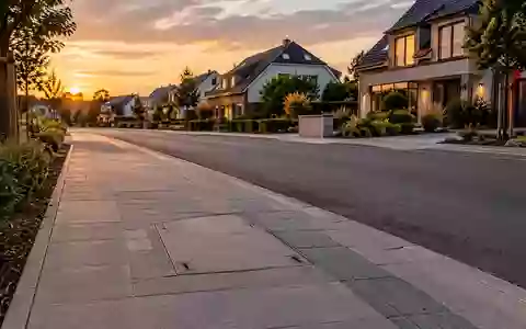 Eine ruhige Wohnstraße mit frisch verlegter Glasfaserinfrastruktur im Gehweg bei Dämmerung. - Foto: über boerse-global.de