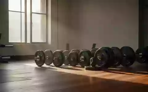 Leeres, minimalistisches Fitnessstudio mit ordentlich gestapelten Hantelscheiben auf einem Holzboden in natürlichem Licht. - Foto: über boerse-global.de
