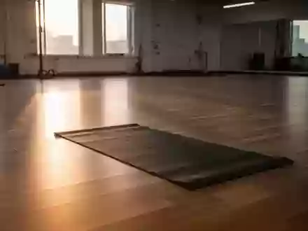 Ein minimalistisch gestalteter Trainingsraum mit einer Yogamatte auf einem Holzboden im sanften Morgenlicht. - Foto: über boerse-global.de