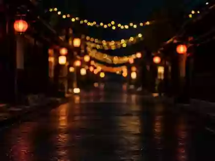 Dunkle, nächtliche Stadtstraße mit unscharfen, festlichen Lichterketten und Laternen im Hintergrund. - Foto: über boerse-global.de