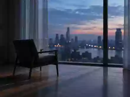 Ein leerer Stuhl in einem minimalistisch eingerichteten Raum vor einem Fenster mit Blick auf eine Stadt bei Dämmerung. - Foto: über boerse-global.de