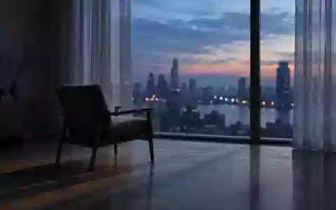 Ein leerer Stuhl in einem minimalistisch eingerichteten Raum vor einem Fenster mit Blick auf eine Stadt bei Dämmerung. - Foto: über boerse-global.de