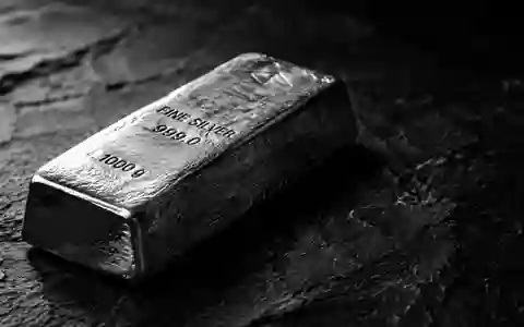 Ein einzelner Silberbarren liegt auf einer dunklen, texturierten Schieferoberfläche bei dramatischem Seitenlicht. - Foto: über boerse-global.de