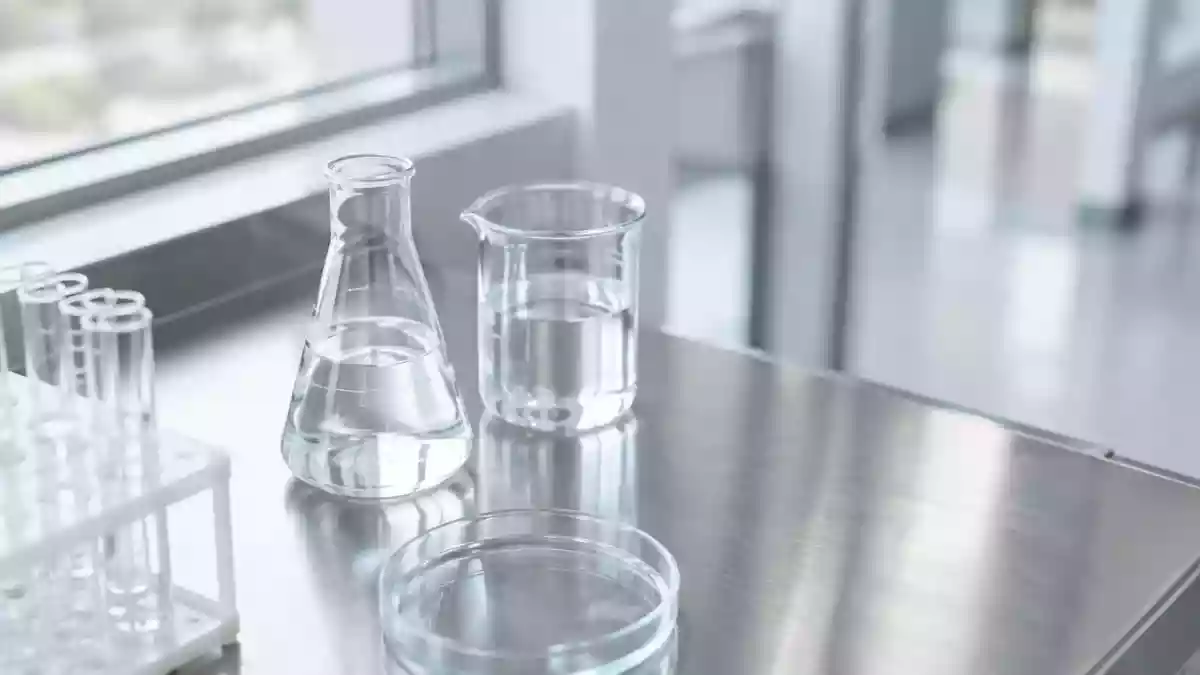 Ein minimalistisch gestalteter, steriler Laborraum mit gläsernen Gefäßen in gedämpftem, natürlichem Tageslicht. Illustration mit AI erstellt.