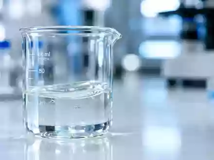 Ein Glasbecher mit einer klaren Flüssigkeit auf einem sterilen Labortisch in einer klinischen Umgebung. - Foto: über boerse-global.de