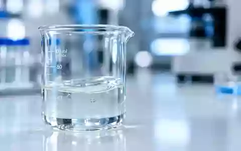 Ein Glasbecher mit einer klaren Flüssigkeit auf einem sterilen Labortisch in einer klinischen Umgebung. - Foto: über boerse-global.de