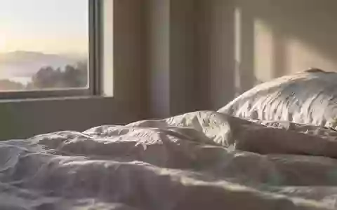 Ein minimalistisches, ruhiges Schlafzimmer bei Tagesanbruch mit Fokus auf die Textur der Bettwäsche und natürliches Licht. - Foto: über boerse-global.de