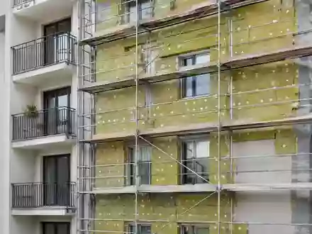 Fassade eines Wohngebäudes während einer energetischen Sanierung mit sichtbarer Wärmedämmung und Gerüst. - Foto: über boerse-global.de