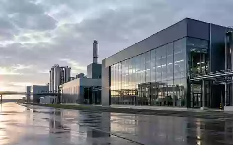 Moderne Industriefassade eines Fertigungsgebäudes im Morgenlicht, die wirtschaftliche Stabilität symbolisiert. - Foto: über boerse-global.de