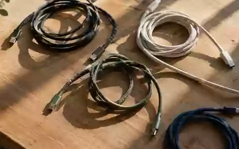 Verschiedene Ladekabel ordentlich auf einer hölzernen Werkbank arrangiert bei natürlichem Lichteinfall. - Foto: über boerse-global.de