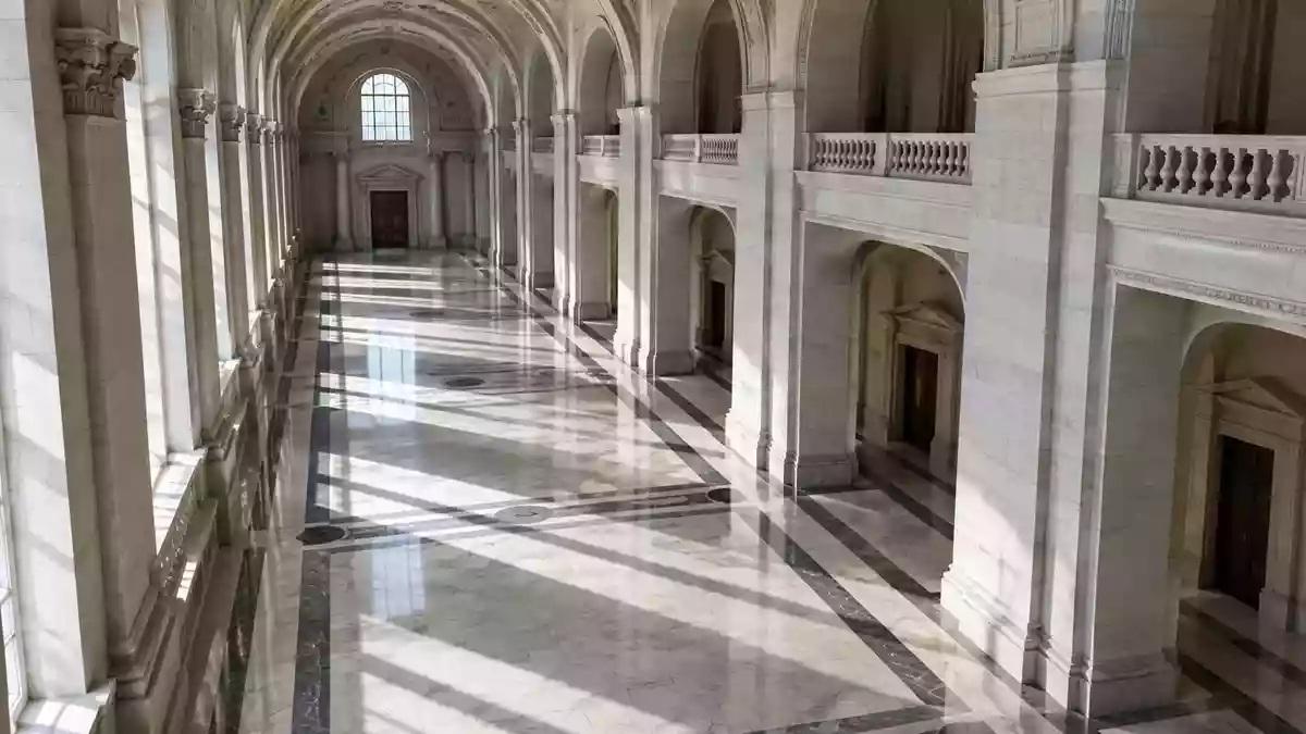 Ein leerer, symmetrischer Flur in einem neoklassizistischen Regierungsgebäude mit poliertem Marmorboden und hohen Bögen. Illustration mit AI erstellt.