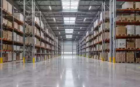 Weitläufiges, modernes Logistiklager mit hohen Regalen und einem sauberen Betonboden in einer neutralen Industriehalle. - Foto: über boerse-global.de