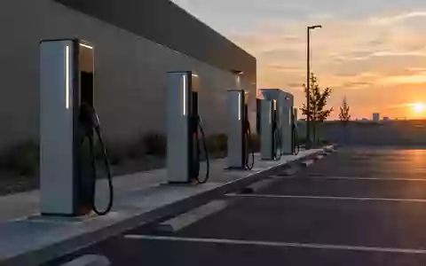Eine Reihe moderner Schnellladestationen für Elektroautos auf einem leeren Parkplatz in der Abenddämmerung. - Foto: über boerse-global.de