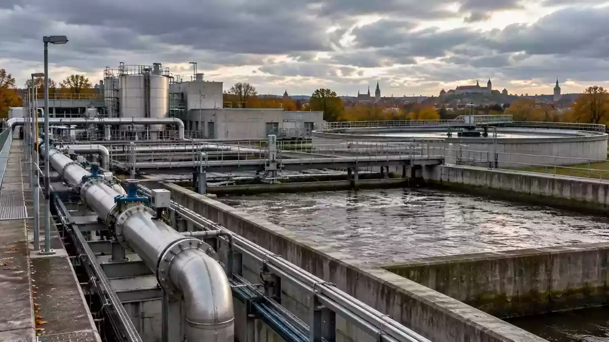Industrielle Infrastruktur einer kommunalen Abwasseranlage mit Betonbecken und Metallrohren in Nürnberg. Illustration mit AI erstellt.